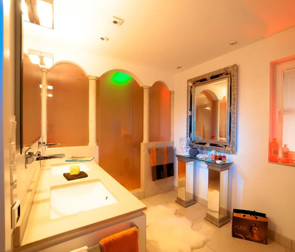 In dieser Badarchitektur für moderner Traumbäder wird ein emotionales Lichtkonzept als Teil der Badezimmer Design Badgestaltung realisiert Der Baddesigner Torsten Müller verwirklichte in dieser Badarchitektur für moderner Traumbäder auch ein emotionales Lichtkonzept als Teil der Badezimmer Design Badgestaltung, das die Stimmung der Bewohner im Bad exklusiv reflektiert. Er installierte im geräumigen Bad exklusive Schattenfugenbeleuchtungen, nutzte beim Bad Einrichten Bodenlichter und kombinierte geschickt direkte und indirekte Lichtquellen miteinander, um beste Badezimmer Effekte zu erzielen. Dieses einmalige Lichtdesign für mediterrane Bäder wird natürlich digital über die innovative KNX-Haus-Bustechnik gesteuert, die auch in Bäderausstellung des Bad Designers in Bad Honnef oder jener der Bäder München genauer unter die Lupe genommen werden kann.