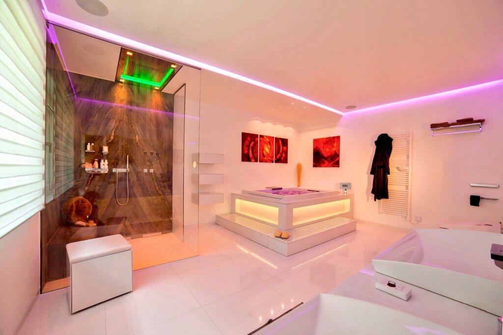 Helles Luxus Badezimmer mit Natursteinregendusche und eckiger Badewanne