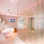 Badezimmer mit pink beleuchteter Dusche und Gräsern - Badezimmer Trends 2024