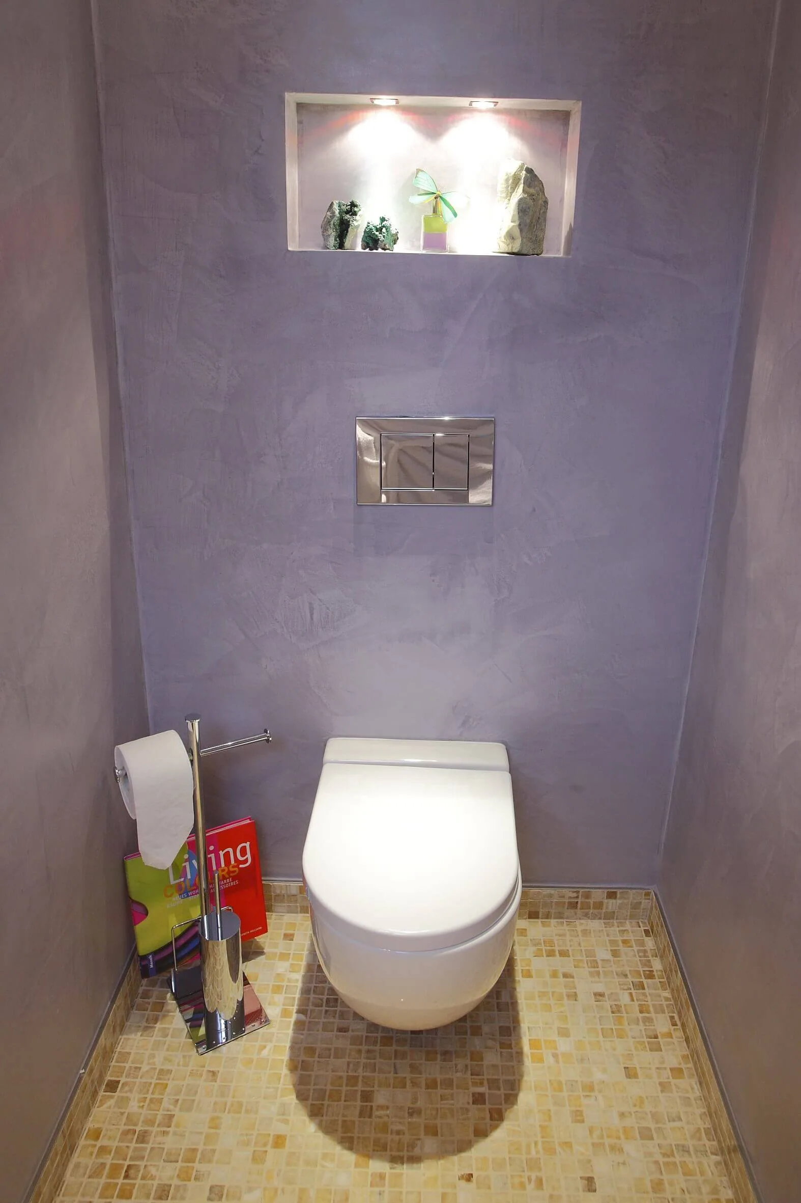 Gäste WC Design mit nebelblauen Wänden und beleuchteter Nische über der Toilette