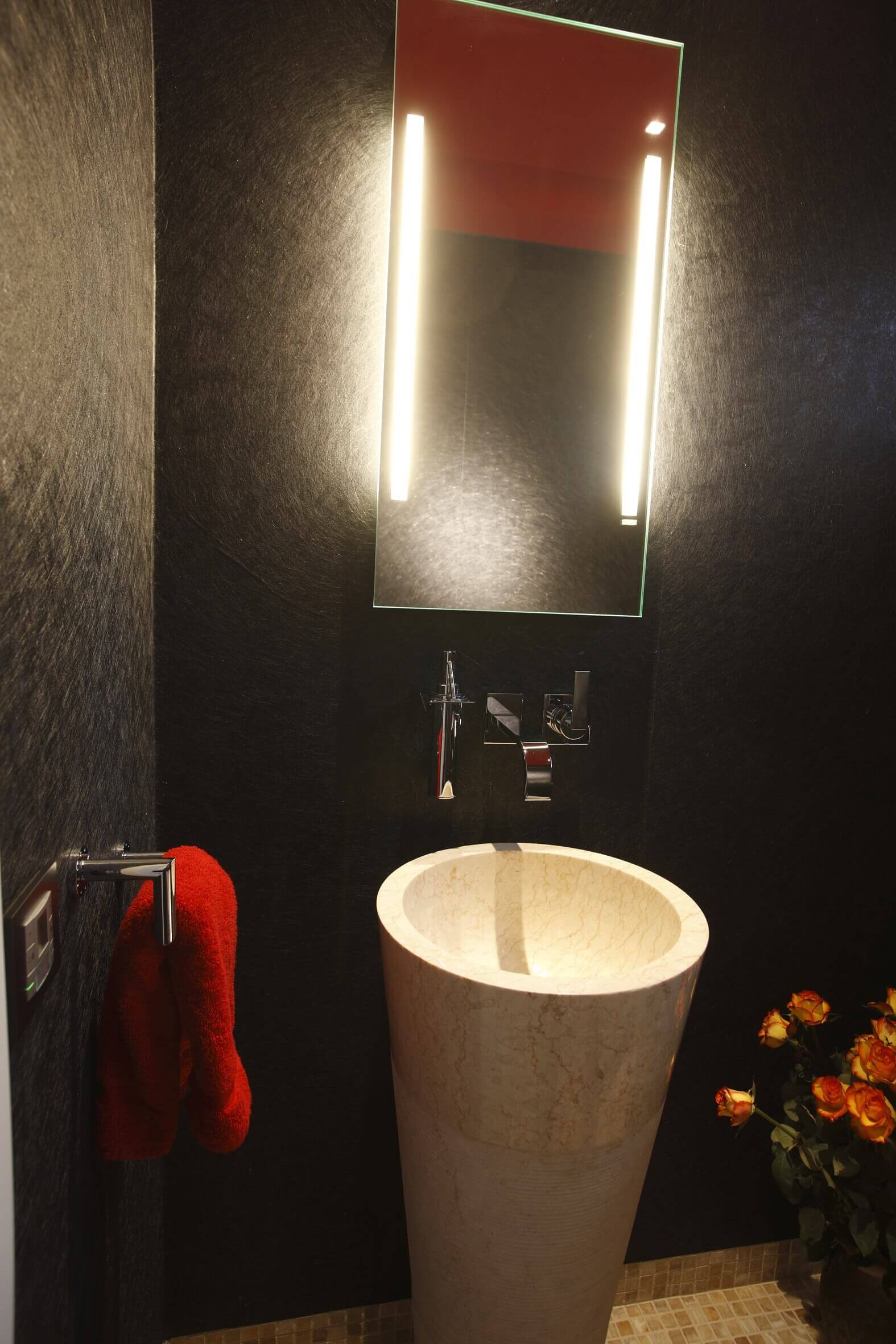 Gäste WC Design mit Waschtonne aus Naturstein und beleuchtetem Spiegel