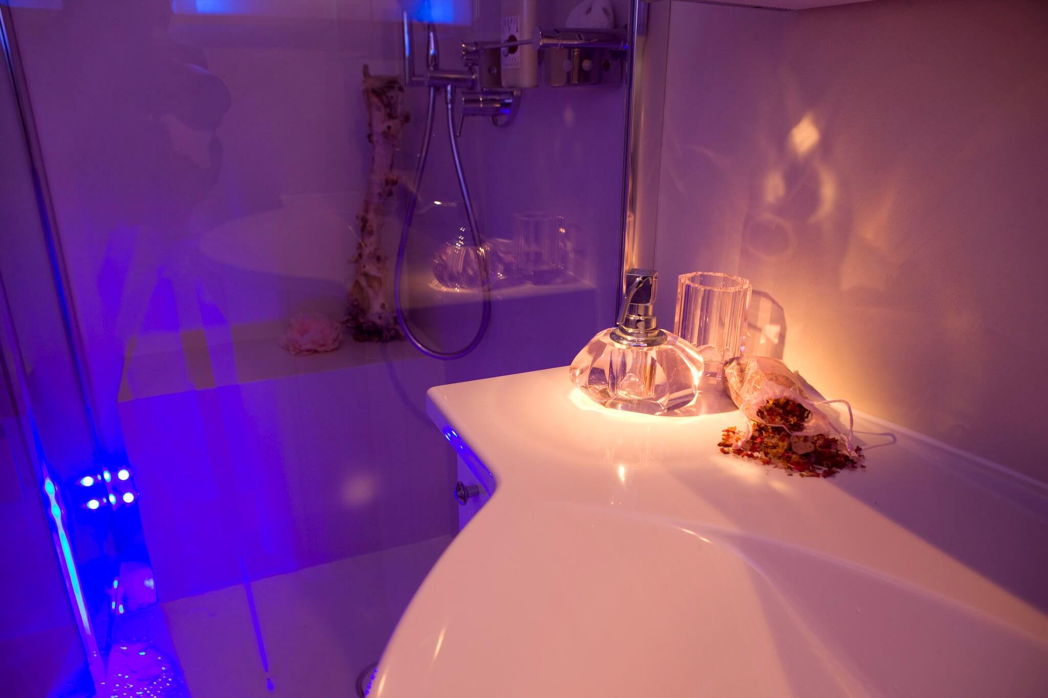 Stimmungsvolle Lichtszenarien im Badezimmer Die Farbtherapie harmonisiert das körperliche und das seelische Wohlbefinden mit Hilfe von Farben. Diese verfügen über eine bestimmte Wellenlänge, die je nach Farbton einen entspannenden oder vitalisierenden Effekt aufweist. Die hinter einer transparenten Glaswand verborgene Regendusche mit LED Leuchten besitzt eine intuitiv zu bedienende Schaltfläche, auf der die einzelnen Impulse individuell eingestellt werden können. Auch eine Programmierung im Voraus erlaubt es in der Früh mit den Strahlen einer aufgehenden Sonne aufzustehen. In dem vorliegenden Projekt wurde der Colorshower der Firma KWS eingebaut, der über moderne Lichtelemente in der Kopfbrause verfügt. Vielseitige Funktionen, wie „Wave“, „Sweep“ und viele mehr lassen die LEDs in einem vorgegebenen Rhythmus aufleuchten, der je nach Wunsch beruhigt oder aufweckt. Auf der beheizten Sitzbank in der bodeneben gestalteten Dusche kann man sich eine Weile von dem Alltag entspannen und all den Stress hinter sich lassen, während von oben warme Wasserstrahlen herabfallen.