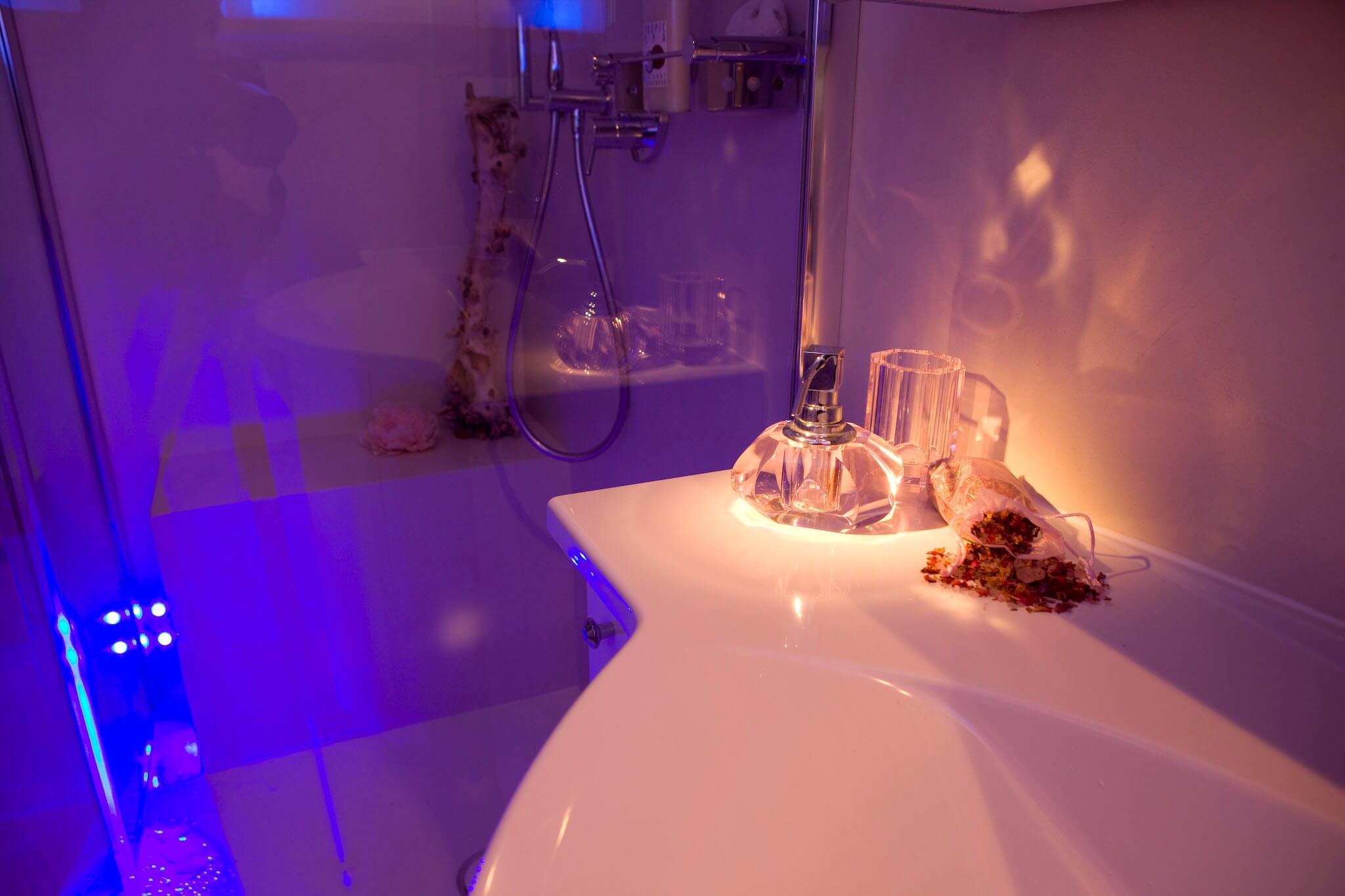 Gaeste Bad mit Licht Dusche als fugenloses Badezimmer vom Designer Torsten Mueller aus Bad Honnef naehe Koeln Bonn Stimmungsvolle Lichtszenarien im Badezimmer Die Farbtherapie harmonisiert das körperliche und das seelische Wohlbefinden mit Hilfe von Farben. Diese verfügen über eine bestimmte Wellenlänge, die je nach Farbton einen entspannenden oder vitalisierenden Effekt aufweist. Die hinter einer transparenten Glaswand verborgene Regendusche mit LED Leuchten besitzt eine intuitiv zu bedienende Schaltfläche, auf der die einzelnen Impulse individuell eingestellt werden können. Auch eine Programmierung im Voraus erlaubt es in der Früh mit den Strahlen einer aufgehenden Sonne aufzustehen. In dem vorliegenden Projekt wurde der Colorshower der Firma KWS eingebaut, der über moderne Lichtelemente in der Kopfbrause verfügt. Vielseitige Funktionen, wie „Wave“, „Sweep“ und viele mehr lassen die LEDs in einem vorgegebenen Rhythmus aufleuchten, der je nach Wunsch beruhigt oder aufweckt. Auf der beheizten Sitzbank in der bodeneben gestalteten Dusche kann man sich eine Weile von dem Alltag entspannen und all den Stress hinter sich lassen, während von oben warme Wasserstrahlen herabfallen.