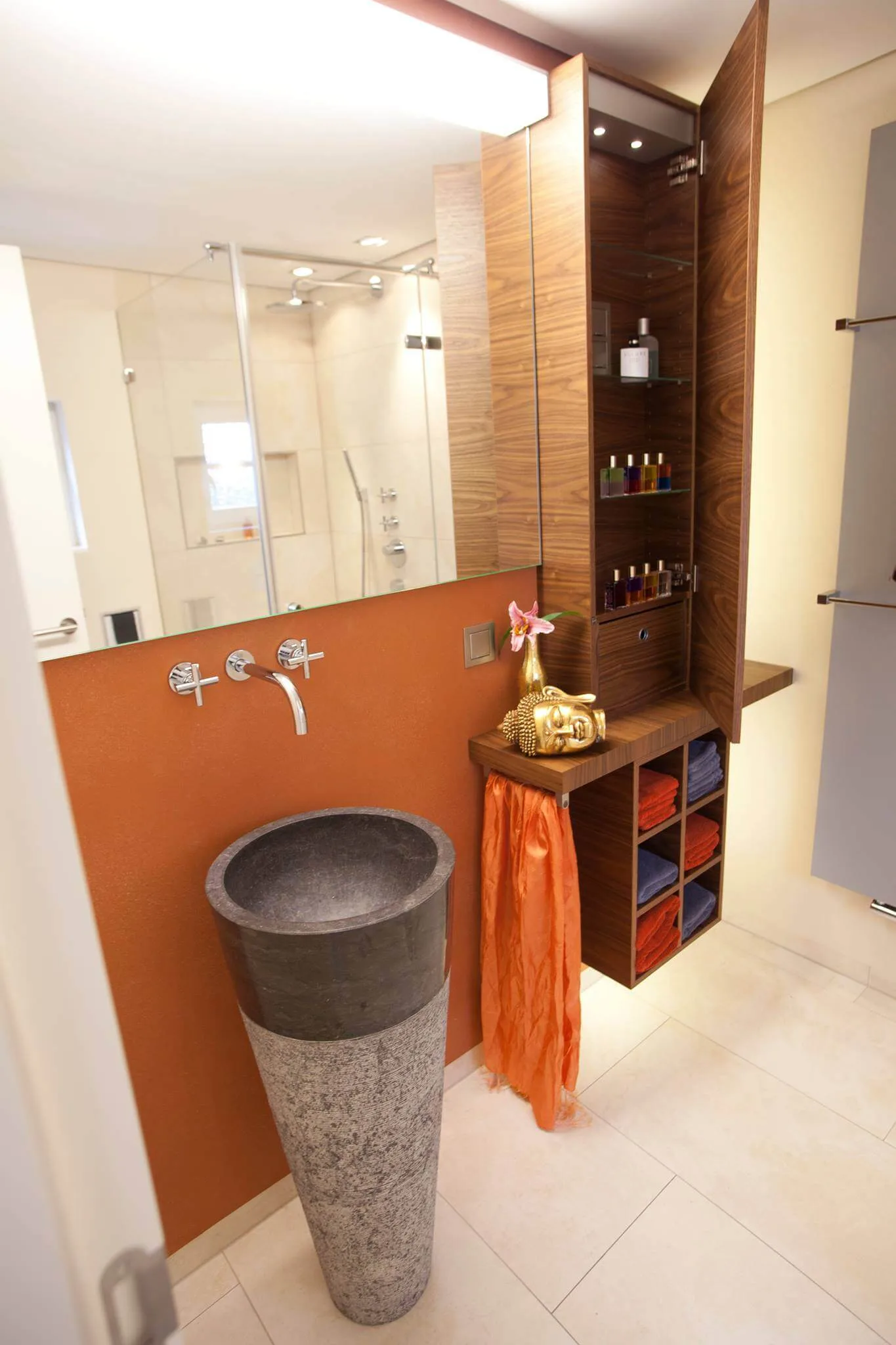 Gäste WC mit stehendem Natursteinwaschbecken sowie hözernem Schrank