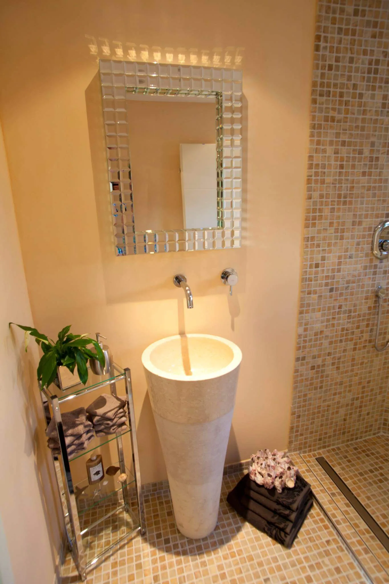 Exklusives Gäste-WC mit Natursteinwaschbecken und Mosaikfliesen in mediterraner Anmutung