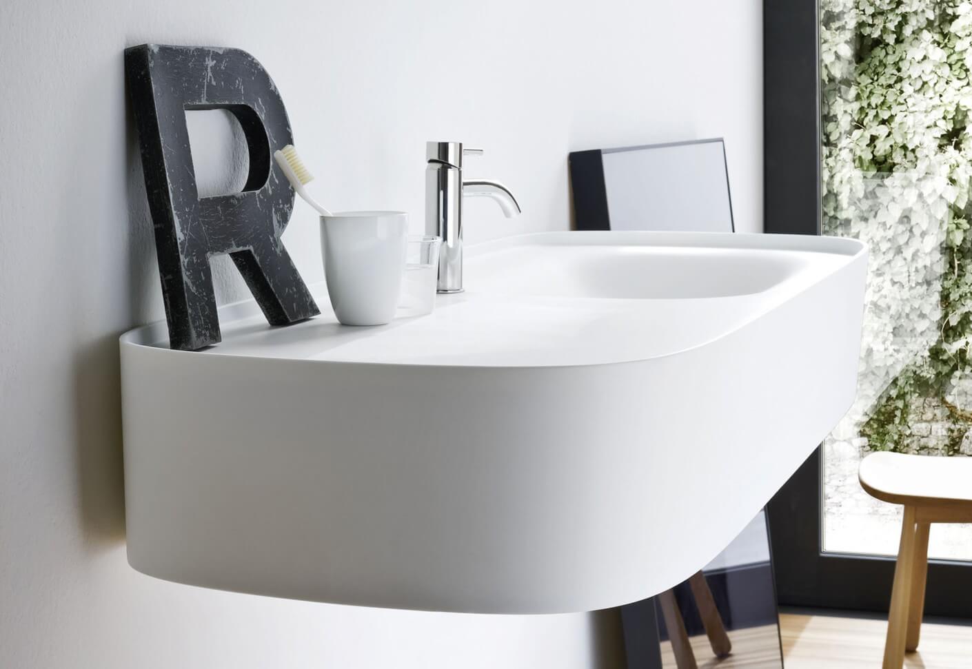 Gäste WC Design am wandmontiertem Waschbecken mit Zahnputzbecker und Buchstabe R als Dekorationsobjekt
