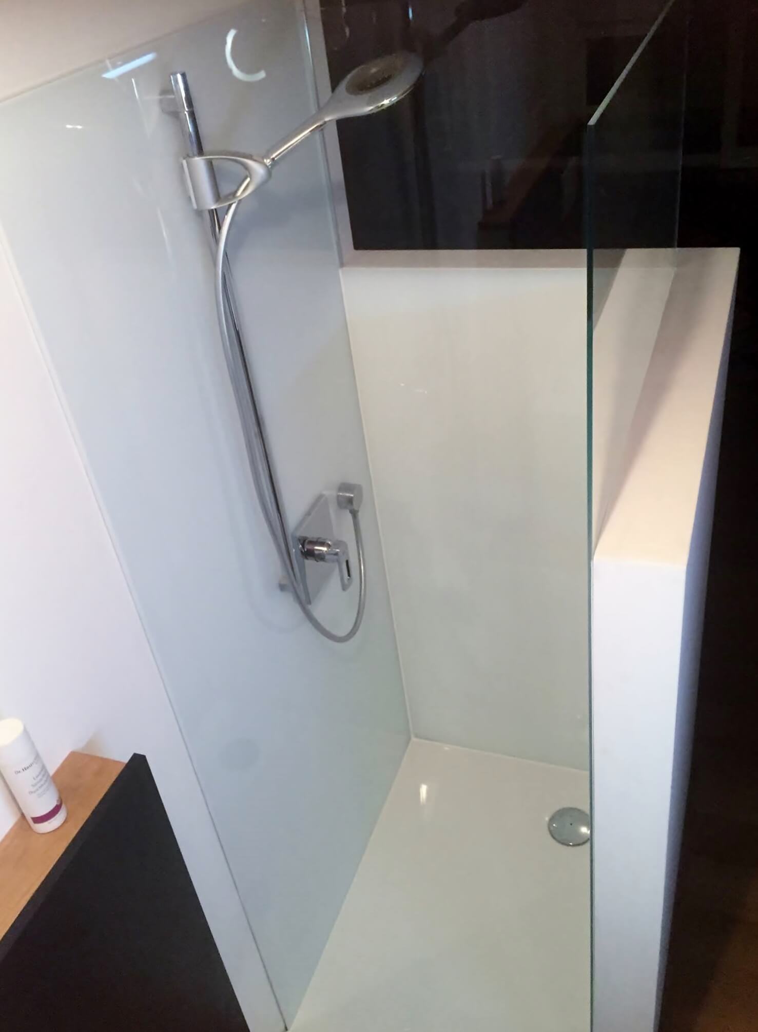 Kleine Dusche mit schwarz-weißen Wänden und Glastüre