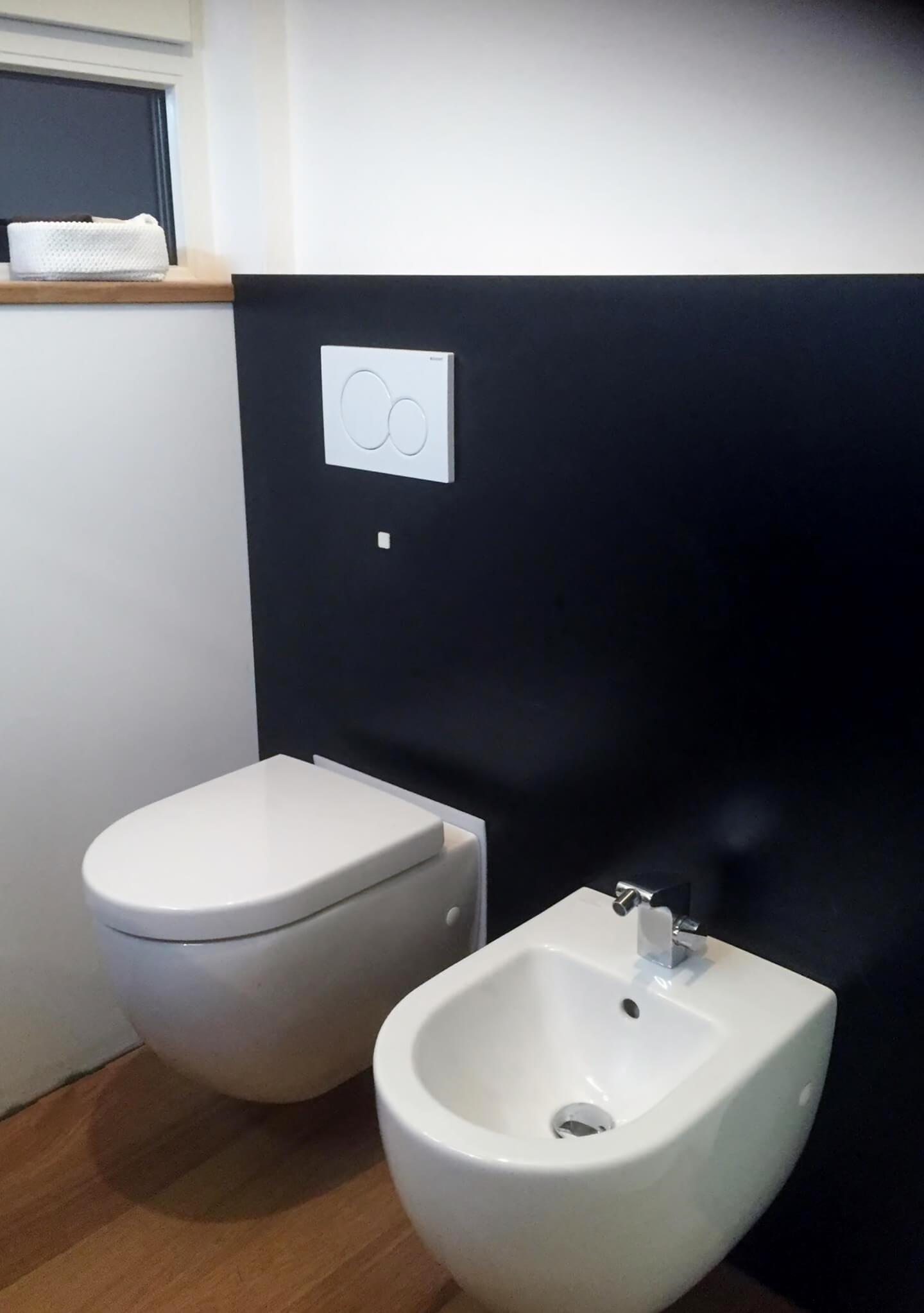 Toilette in schwarz-weiß WC und Bidet vor einer tief schwarzen Rückwand