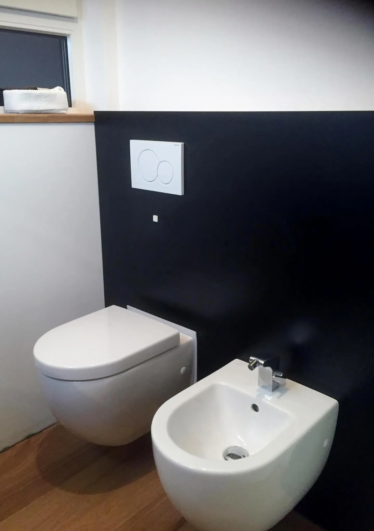 Toilette in schwarz-weiß WC und Bidet vor einer tief schwarzen Rückwand
