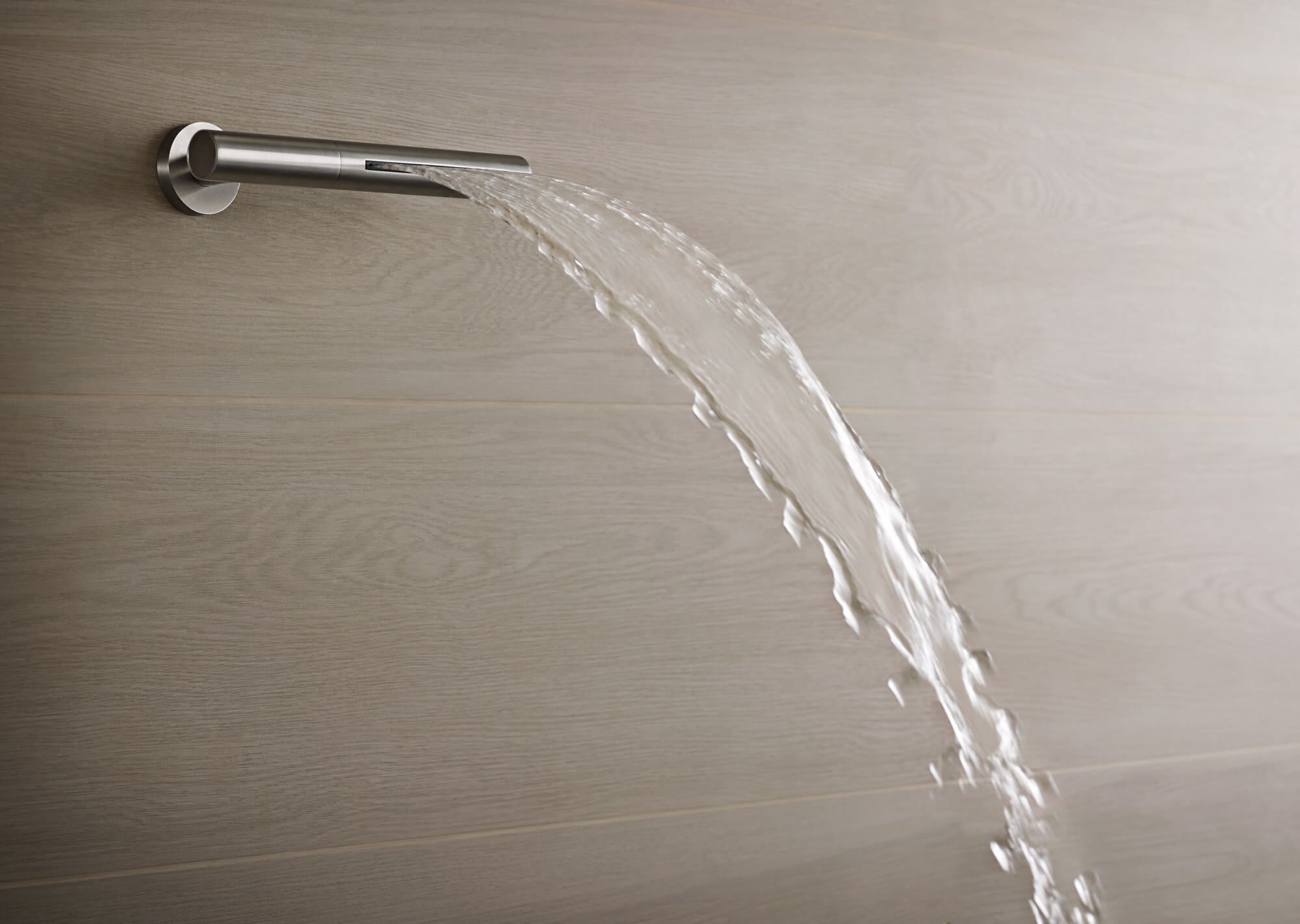 Luxusdusche von Vola Schwallartiger Wasseraustritt aus edelstahlfarbener Vola Luxusdusche