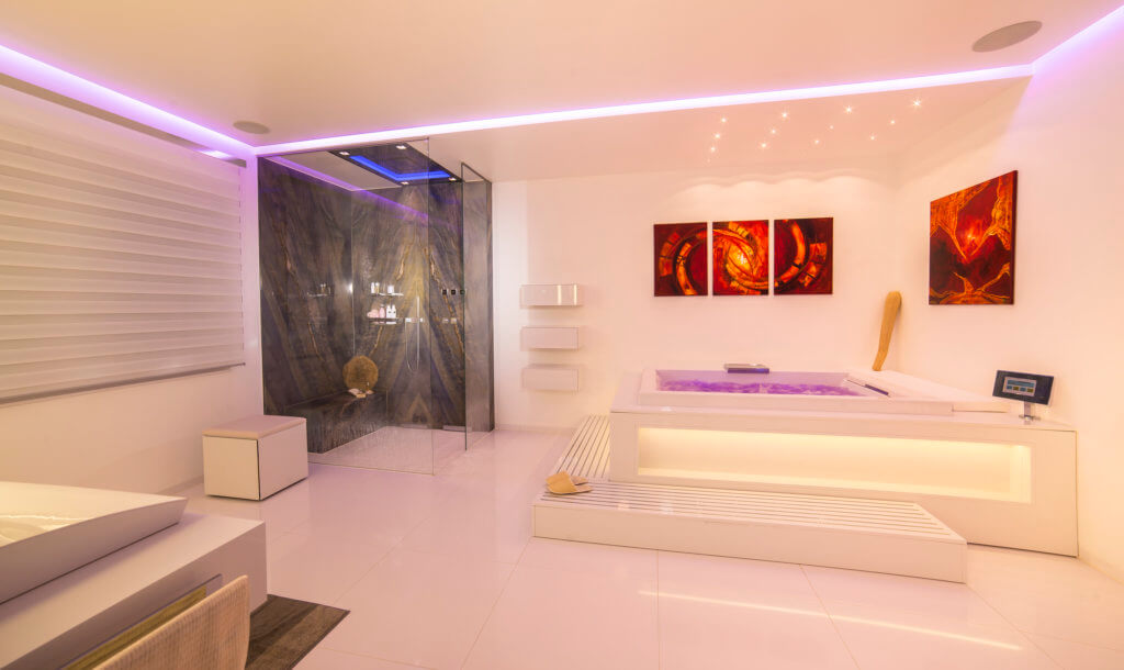 Luxus Badezimmer mit geräumiger Natursteindusche und Badewanne mit Beleuchtung