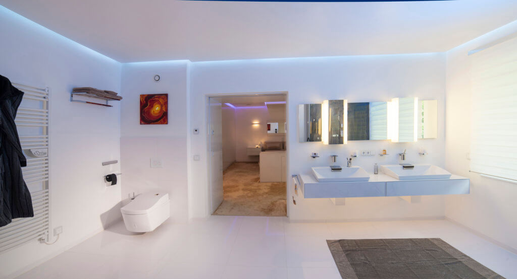 Luxus Badezimmer in Weiß mit Waschlet, geoßem Waschbereich für zwei und beleuchteten Spiegeln
