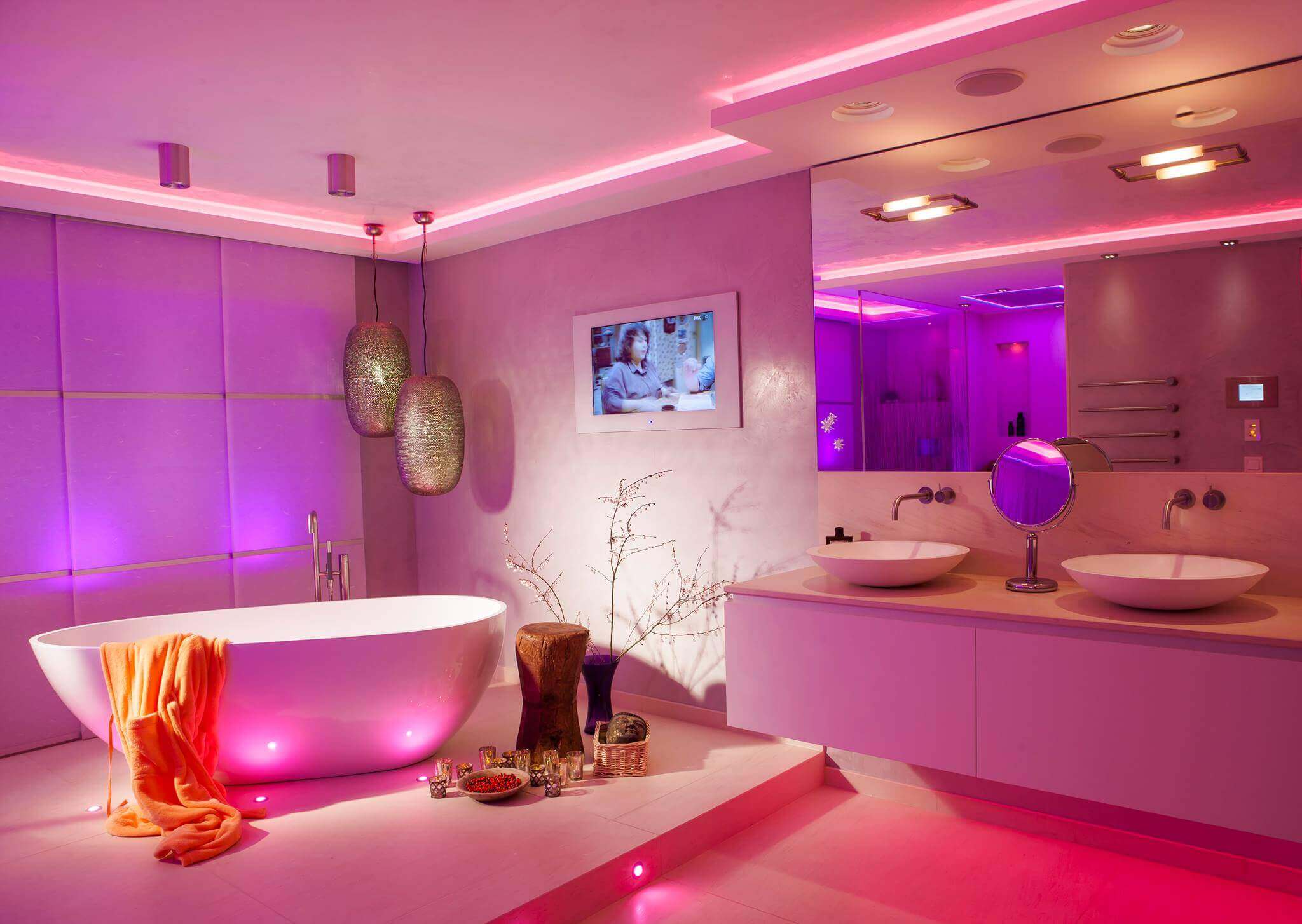 Badezimmer mit freistehender Wanne und Waschbereich für zwei mit violetter Beleuchtung durch LED Profilelemente