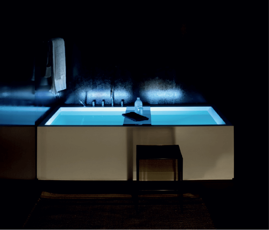 Schwarz-weiße Badewanne mit Milch Honig Bad und blauer Beleuchtung