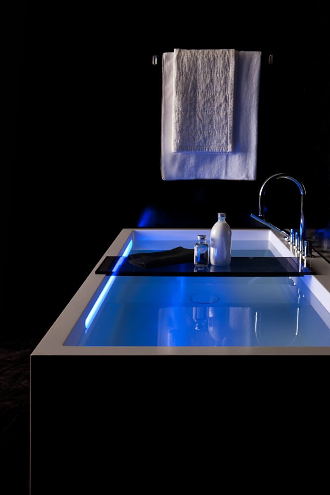 Rechteckige schwarz-weiße Badewanne mit Milch Honig Bad und blauer Beleuchtung