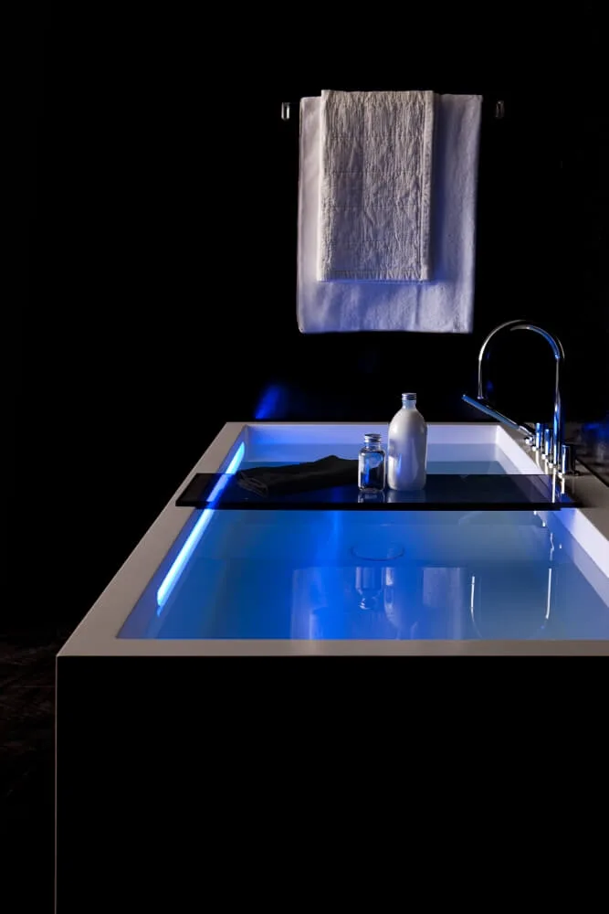 Badewanne mit Milch Honig Bad Rechteckige schwarz-weiße Badewanne mit Milch Honig Bad und blauer Beleuchtung