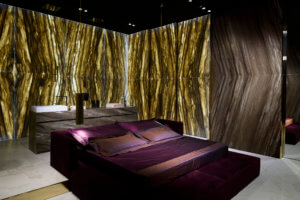 Violettes Bett und Natursteinwanne im grossen Badezimmer en suite
