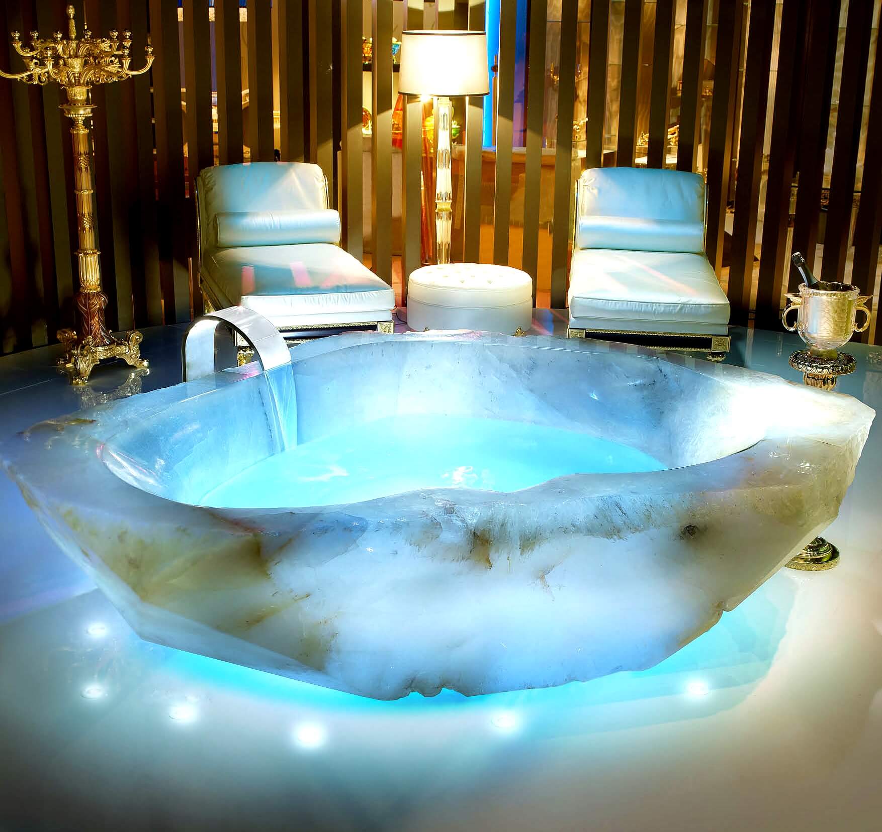 Quarz Badewanne mit türkister Beleuchtung mit zwei Liegen und goldenem Armleuchter