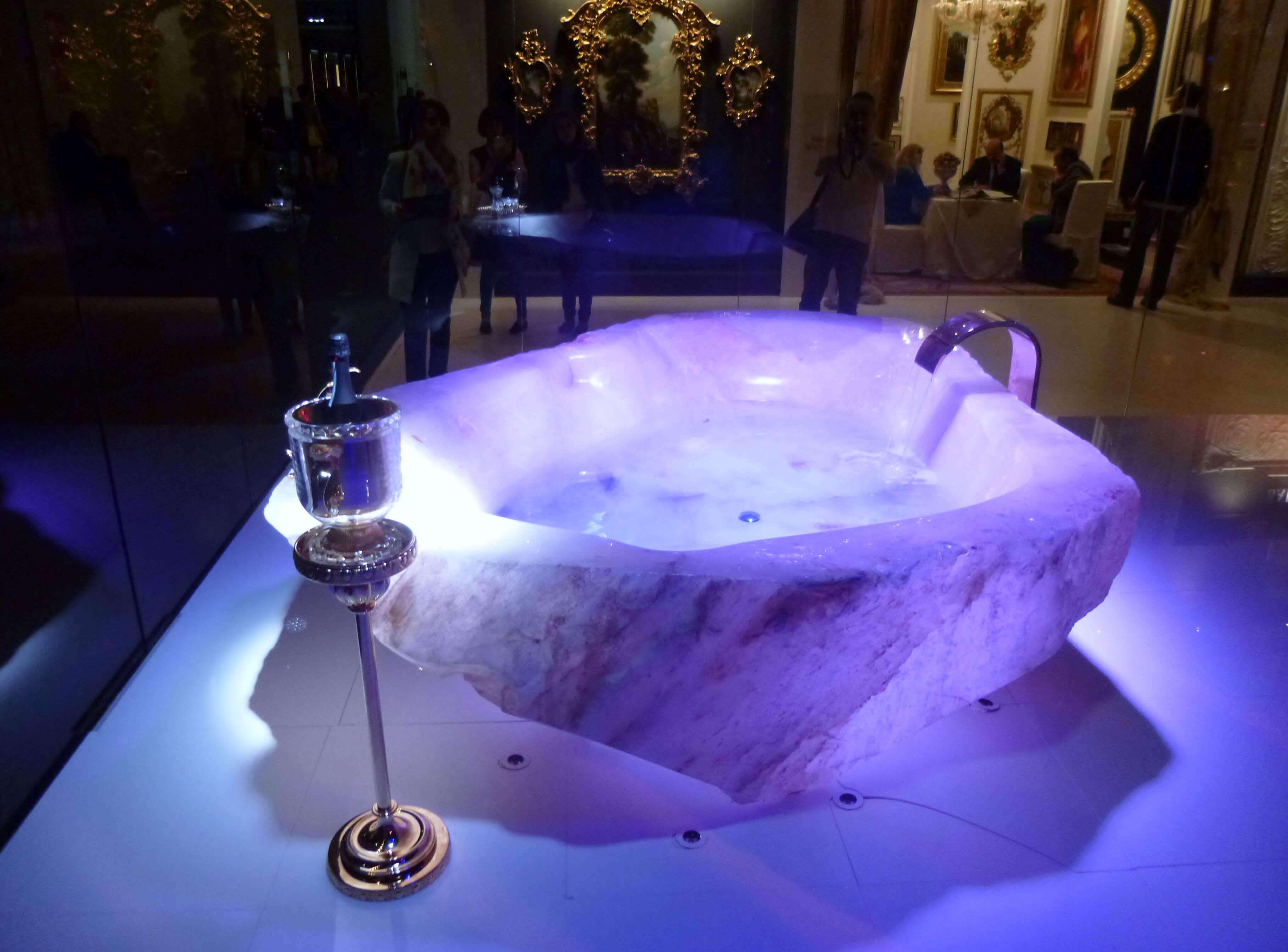 Präsentation der Rosenquarz Badewanne Rosenquarz Badewanne mit glänzender Standarmatur und Champagnerkübel bei einer Ausstellung