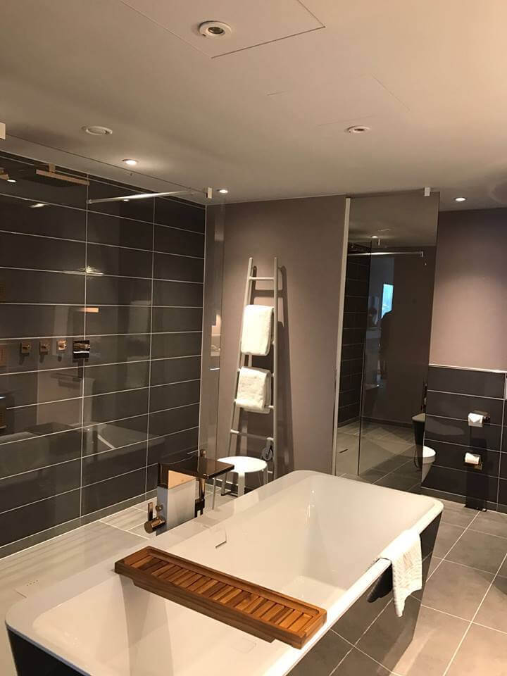 Schwarz-weißes Badezimmer mit Tubes Heizkörper Badezimmer mit freistehender Wanne, Dusche sowie leiterförmigem weißen Tubes Heizkörper