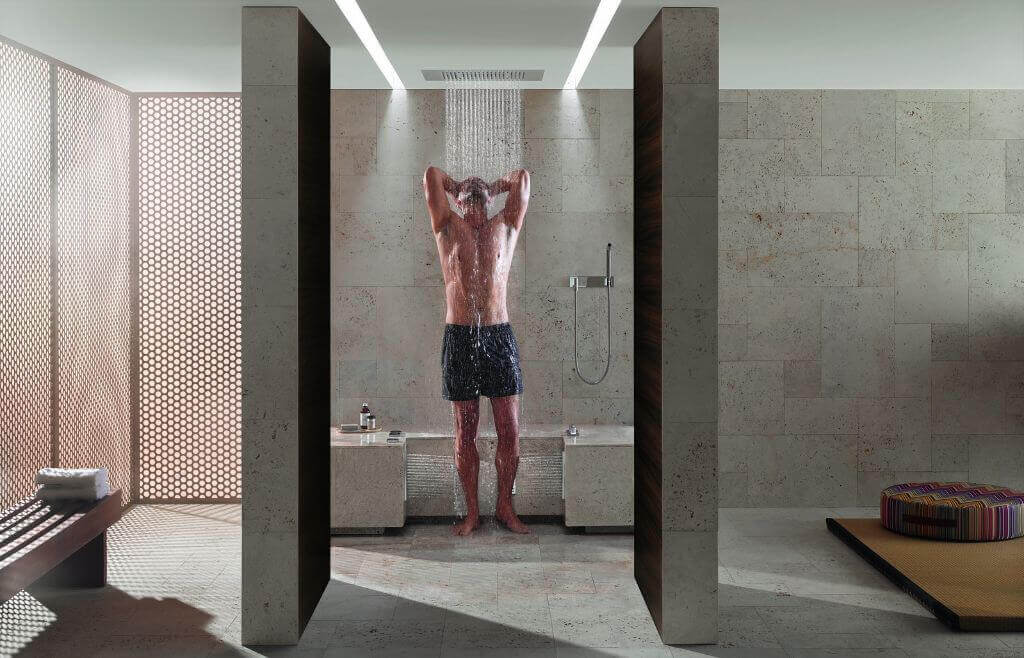 Luxusdusche Leg Shower von Dornbracht Mann unter graugefliester Luxusduschemit Wechselduscheneffekt von Dornbracht