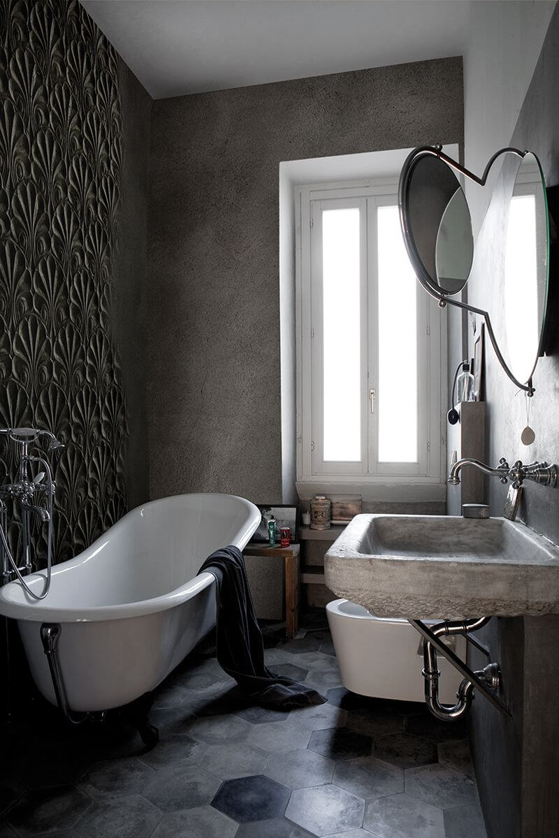 Kleines Badezimmer mit freistehender Vintage-Wanne, Toilette und Waschbereich sowie dunkler Wall and Deco Tapete