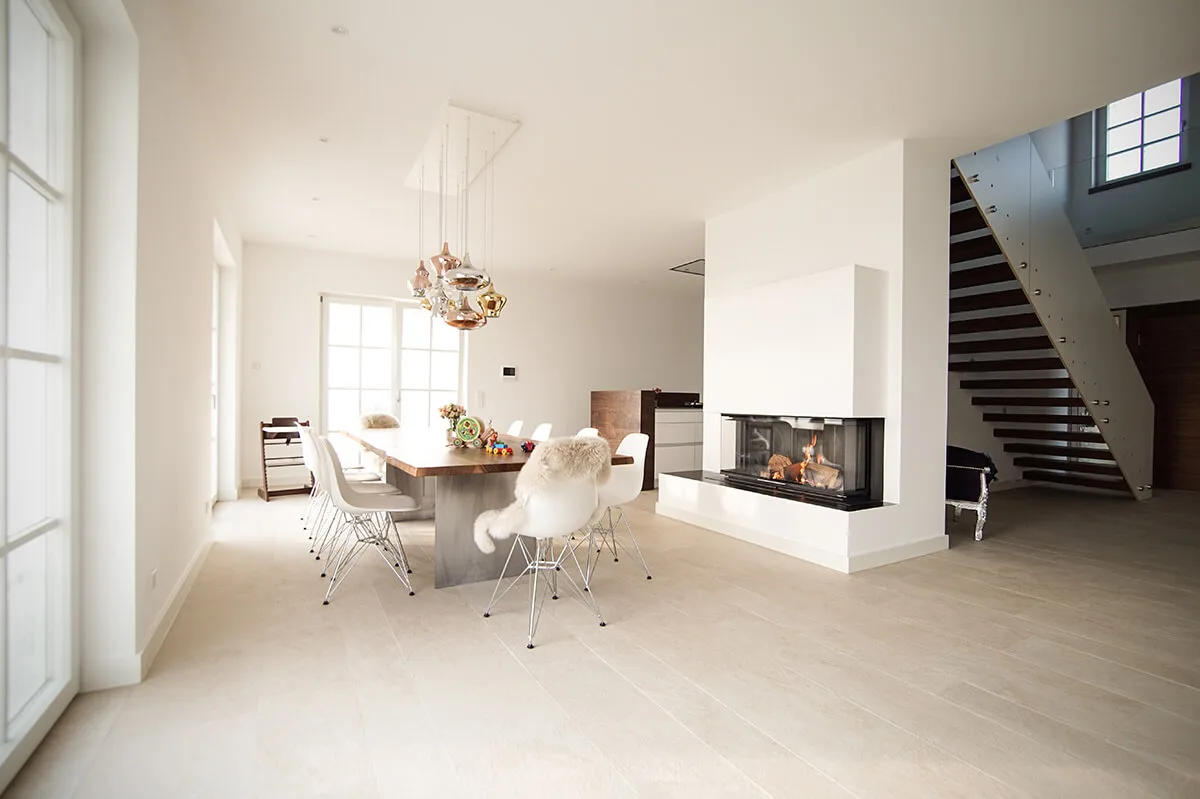Esszimmer in Weiß Weißes Esszimmer mit langem Esstisch, Kamin und Treppe