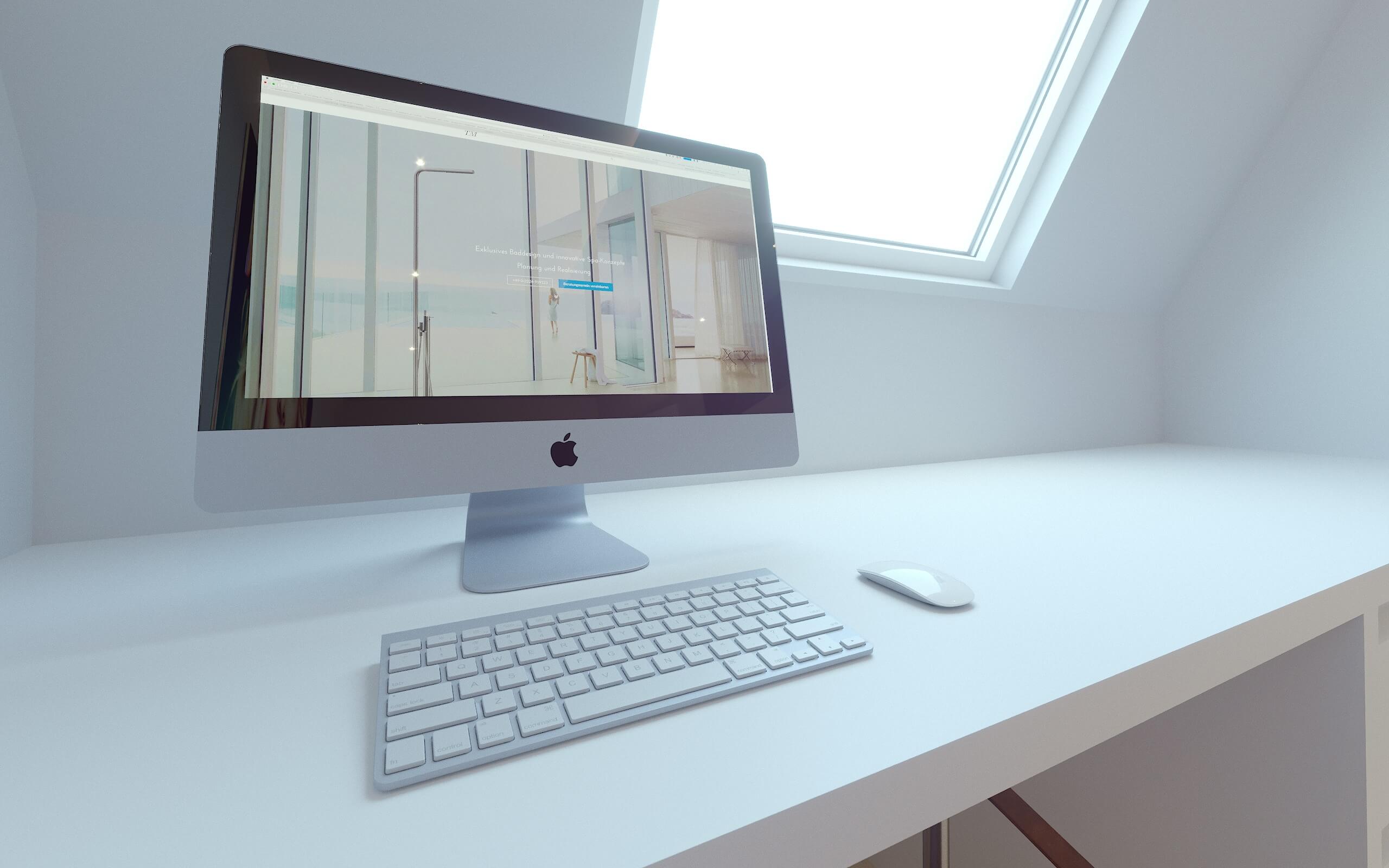 Monitor vor Dachschräge mit Fenster Apple-Monitor und weiße Tastatur auf weißem Schreibtisch vor einer Dachschräge mit Fenster