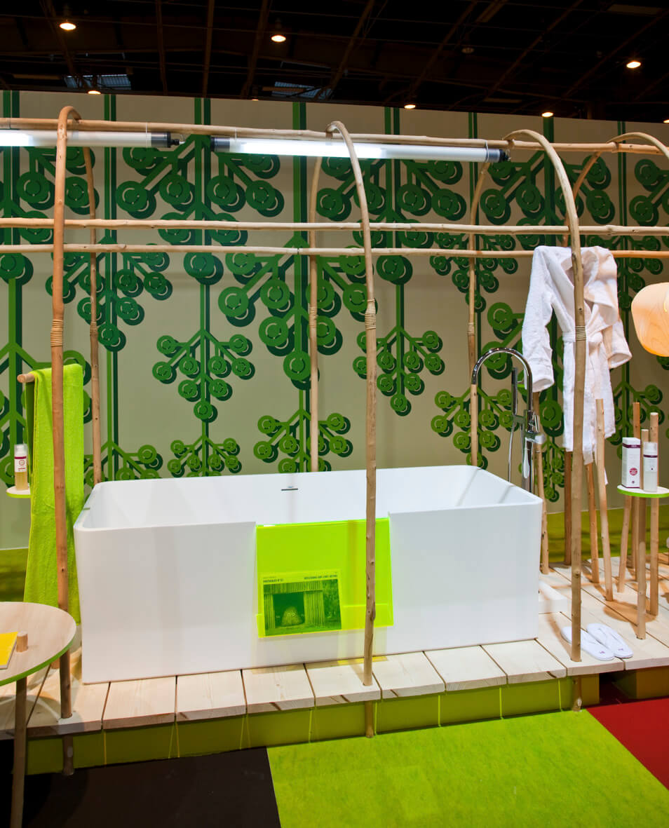 Rechteckige Luxusbadewanne unter glashausartiger Konstruktion und grüner Tapete
