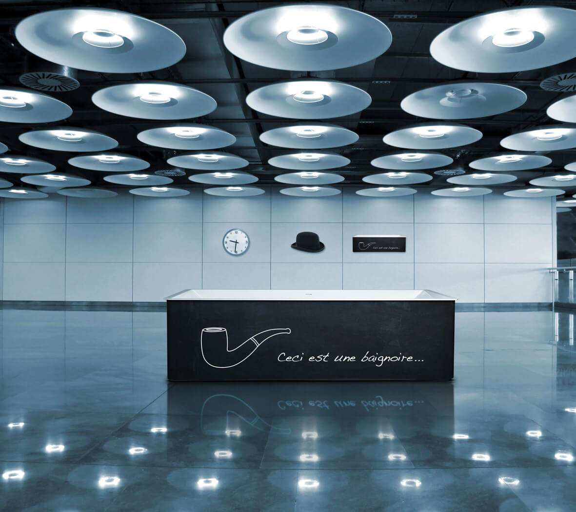 Luxusbadewanne mit Zeichnung Luxus Badewanne in dunkelgrau mit Zeichnung einer Pfeiffe und Aufschrift in leerer Halle