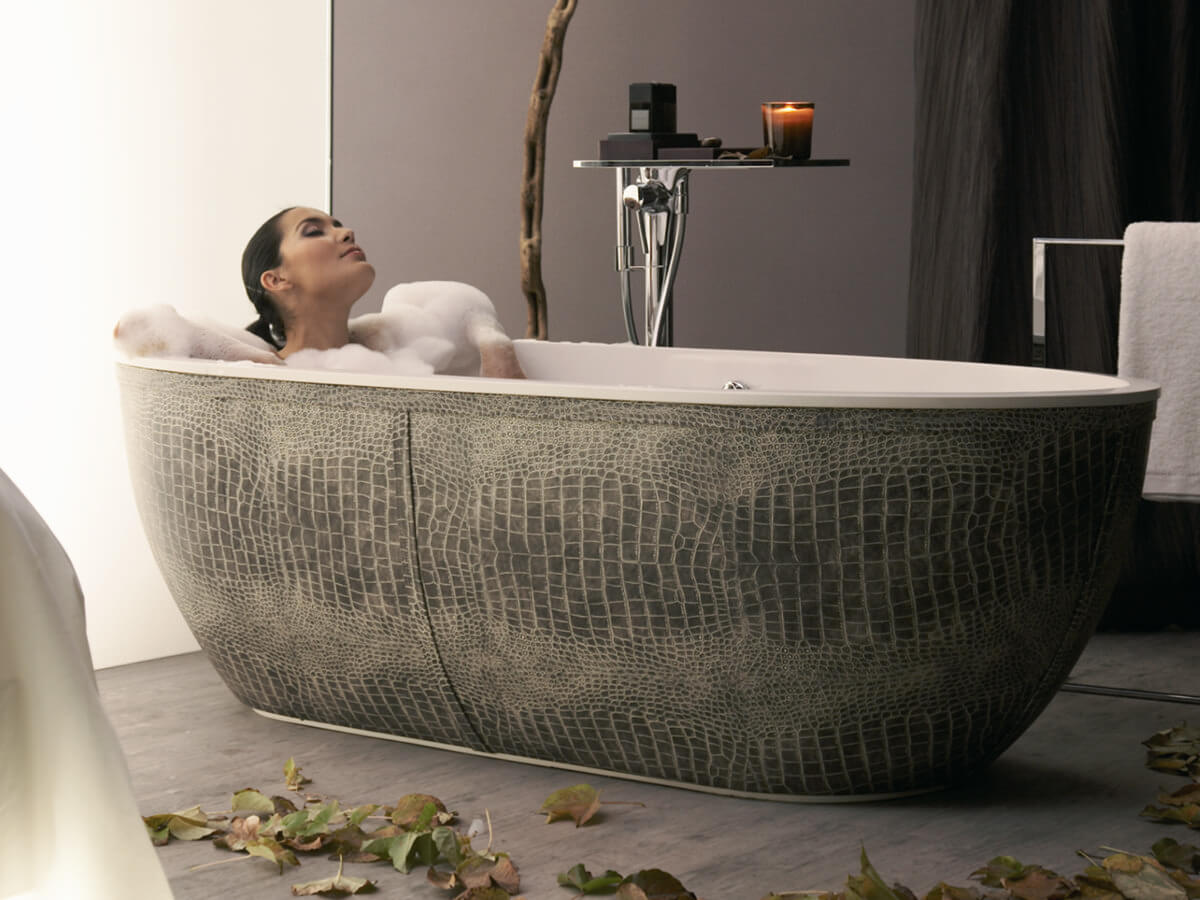 Frau in Luxus Badewanne in Schlangenoptik Frau nimmt Schaumbad in Luxus Badewanne in grauer Phytonoptik