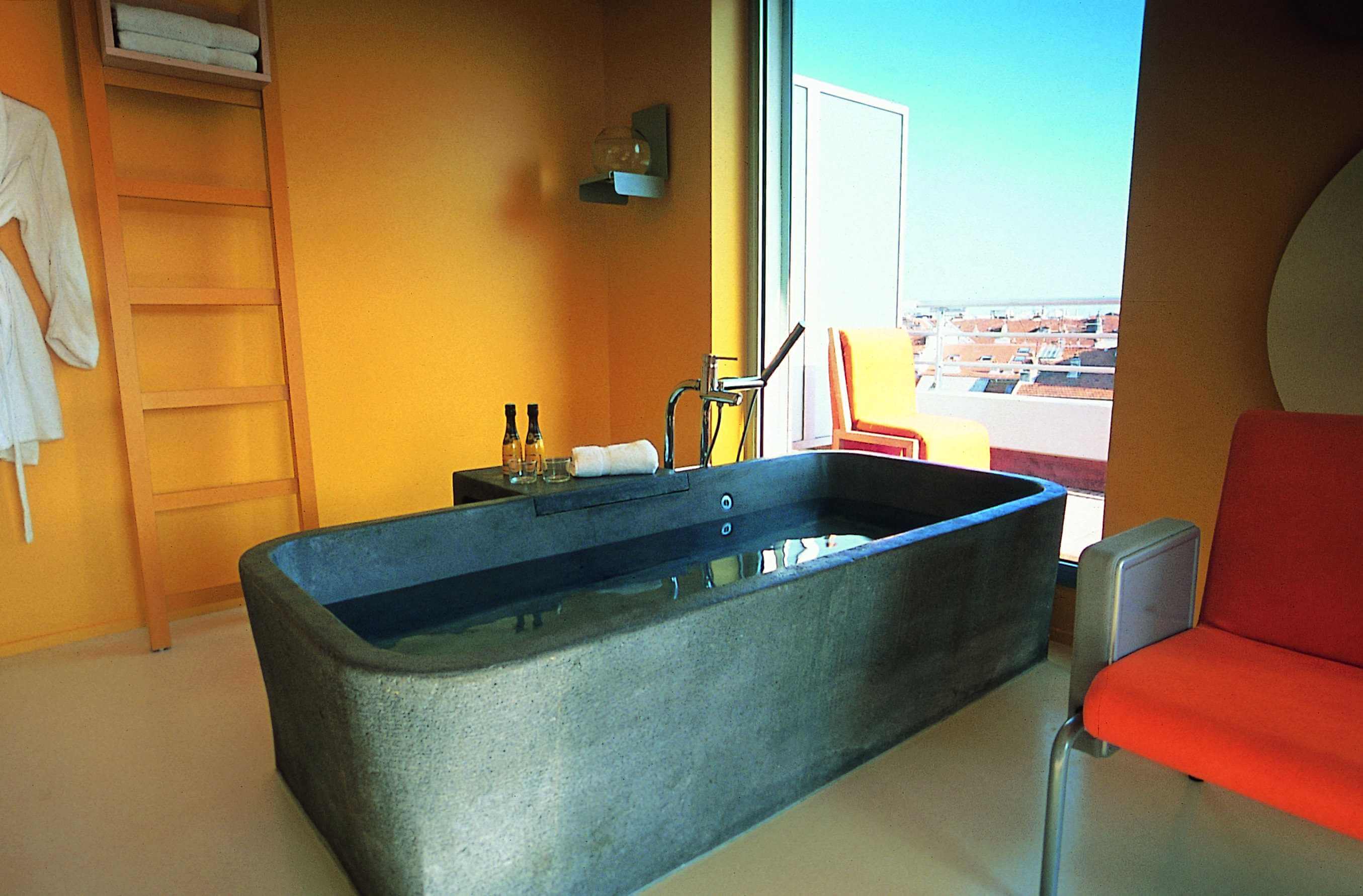 Luxus Badewanne in rechteckiger Form in Betonoptik vor offener Terrassentür