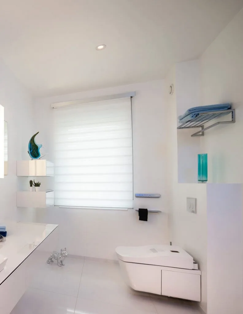 Weißes Gäste-WC mit Fenster und blauen Accessoiores