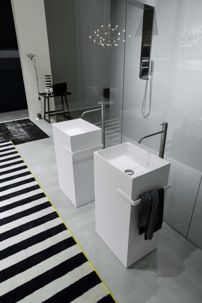 Zwei säulenförmige Standwaschbecken in Weiß vor einer minimalistischen bodenebenen Dusche
