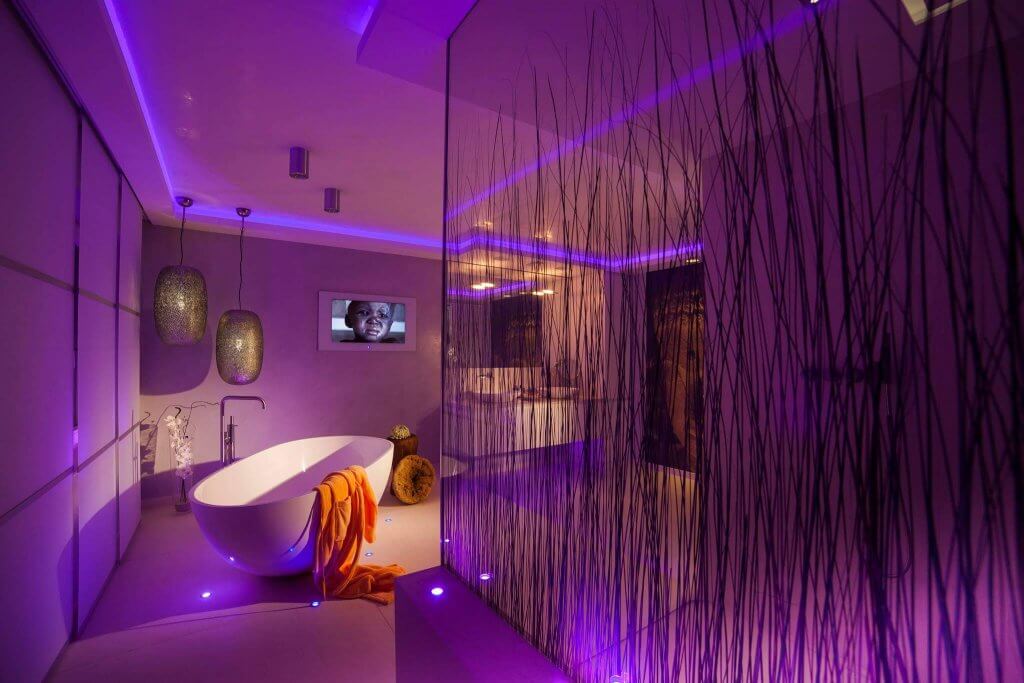 Badezimmer mit freistehender Wanne und ausgeklügeltem Lichtkonzept mit farbigen LEDs