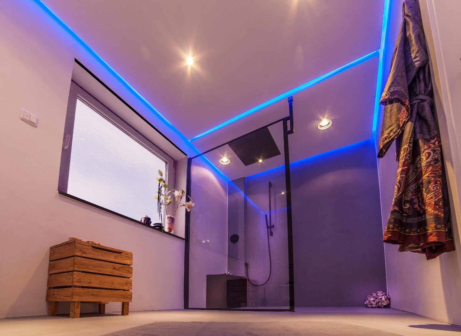 Fugenloses Bad in hellem Taupeton mit blauer LED-Beleuchtung