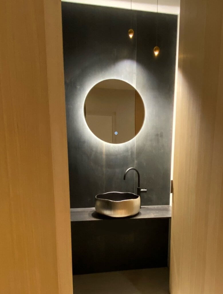 Badausstellung mit goldenem myglassdesign Waschbecken und rundem Spiegel