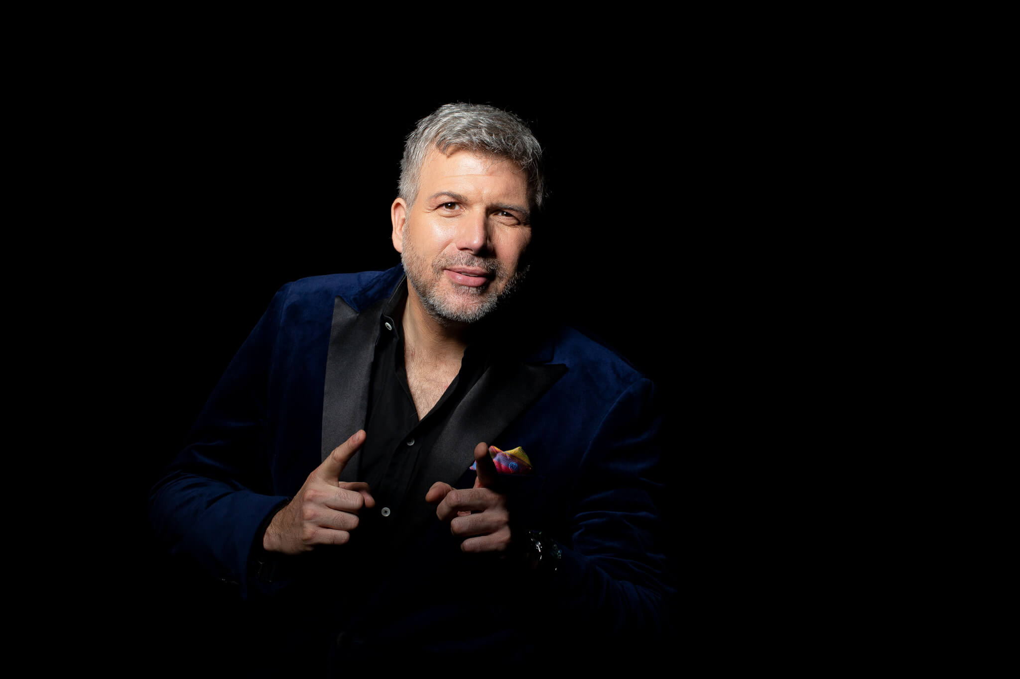 Torsten Müller in blauem Sakko mit schwarzem Revers wendet sich dem Leser vor schwarzem Hintergrund zu