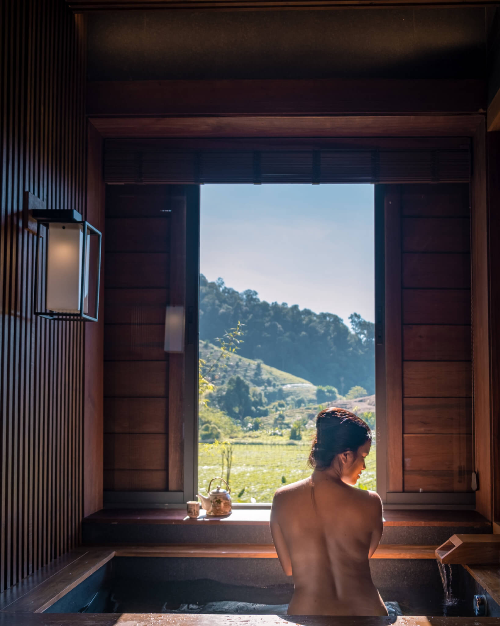 Frau im Onsenbad mit Alpenblick Frau in Wasserbecken im Onsenbad mit Aussicht