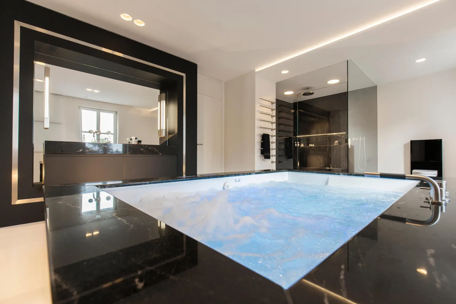 Waschtisch aus schwarzem Naturstein mit Spiegel, Projekt Luxusbad in purem Schwarz