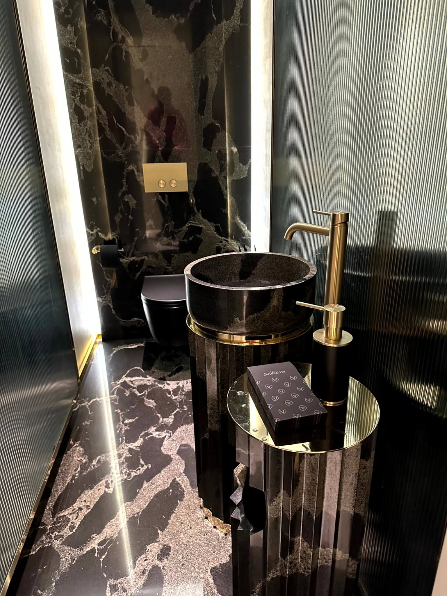 Gäste-WC von Antolini Naturstein in Schwarz-Gold auf der Milano Design Week 2023