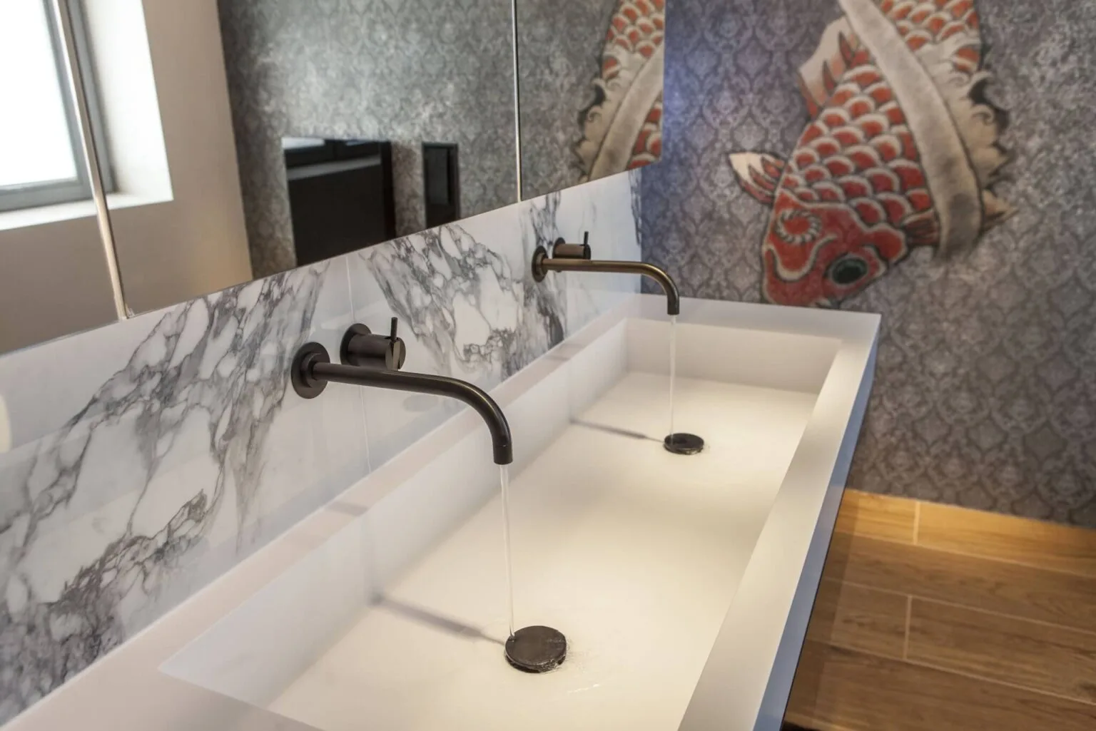 Doppelwaschtisch aus Corian vor Marmorwand und Koi-Tapete, Projekt Exklusive Badprojekte