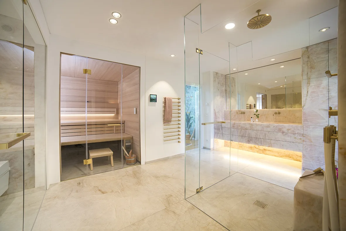 Großzügiges Penthouse-Private-Spa mit Sauna, Glasdusche und rosa Naturstein