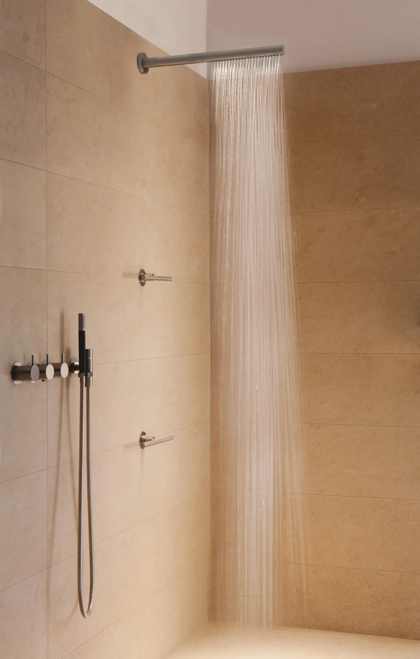 Vola Dusche mit Wandarmaturen und Regenduschkopf in einem minimalistischen Badezimmer