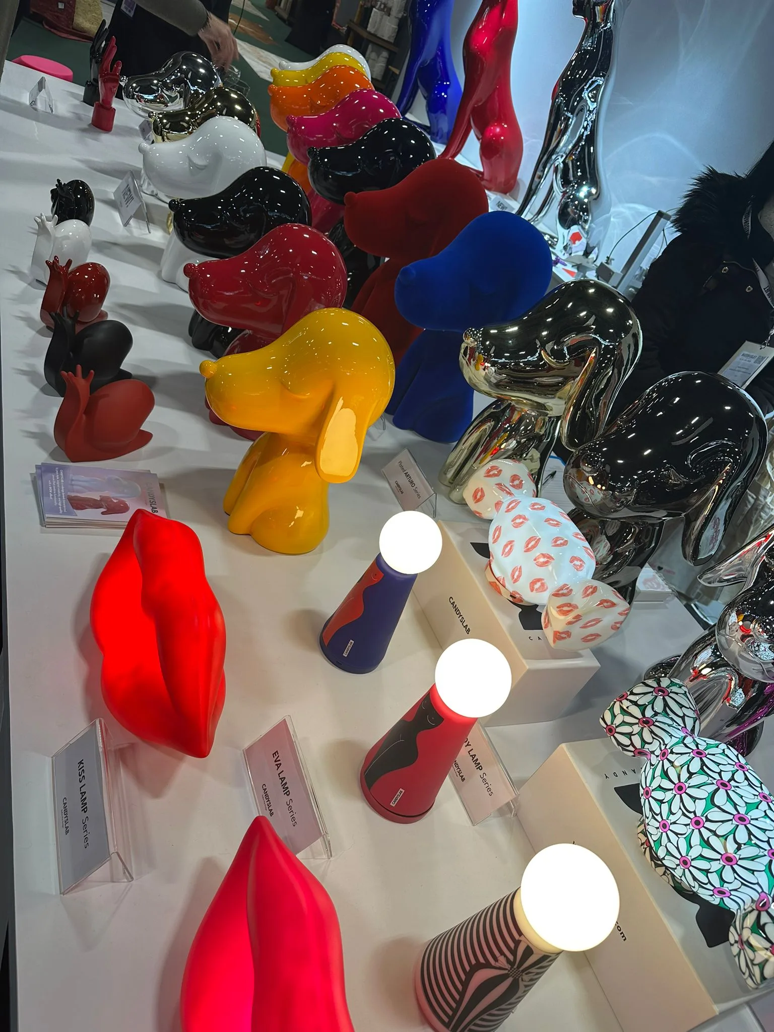 Bunte und kreative Designerstücke, darunter abstrakte Figuren und stilvolle Tischlampen, ausgestellt auf der Maison & Objet 2025.