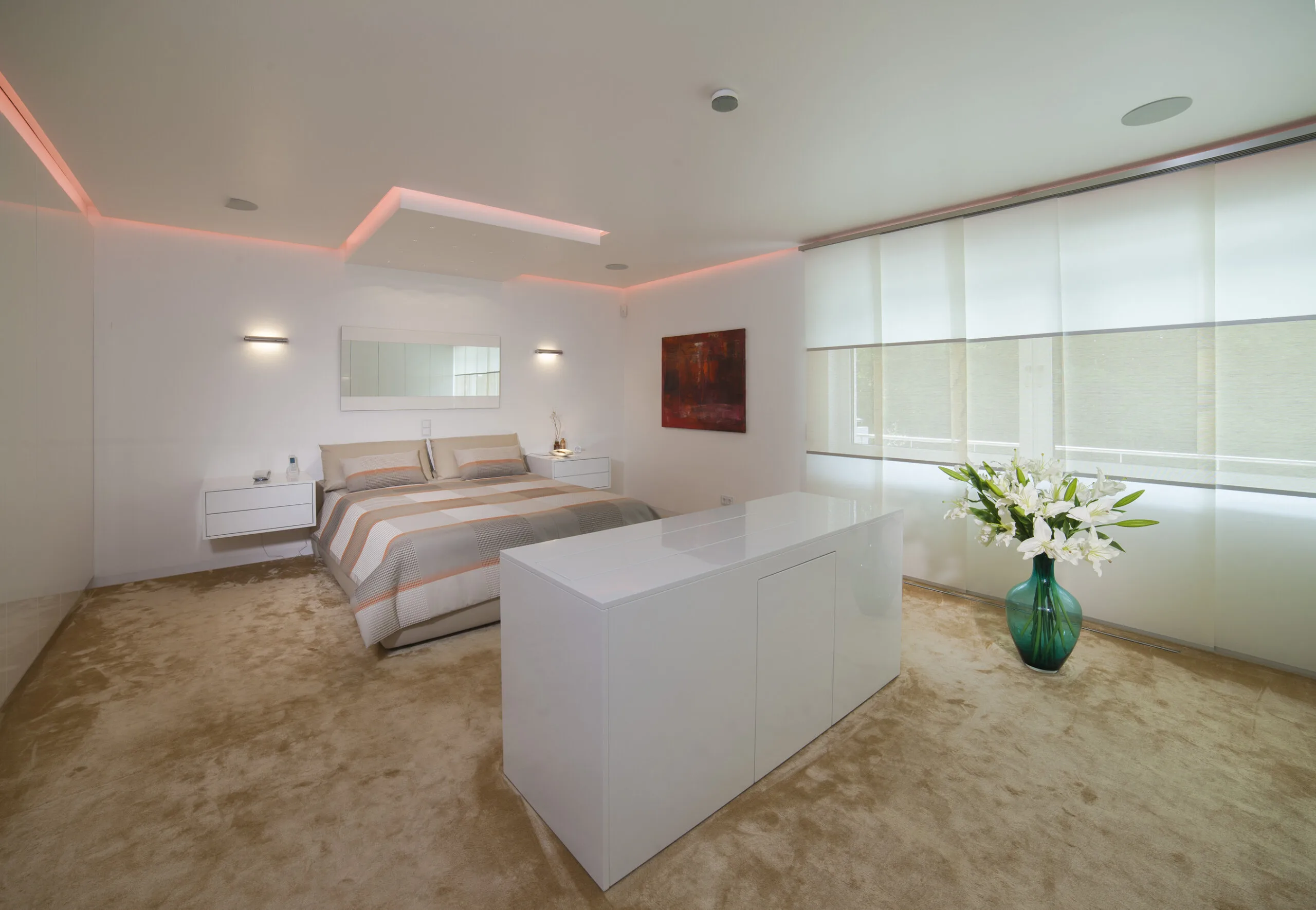 Schlafzimmer mit TV-Möbel, roséfarbener Lichtvoute und modernen Schiebegardinen