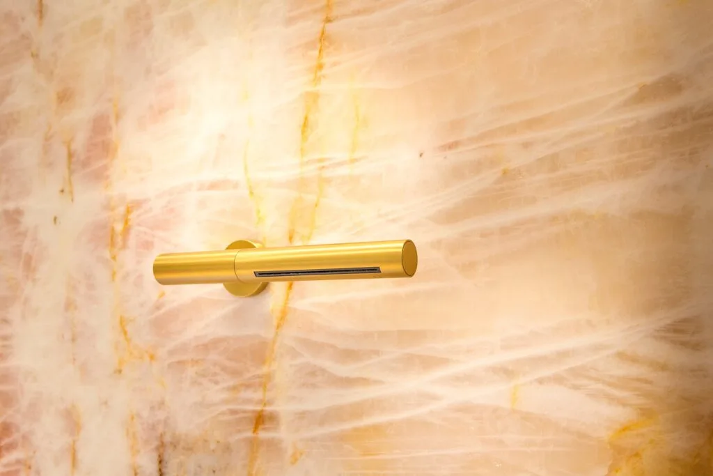 Schwallbrause von Vola in Gold gebürstet. Bad und Private Spa mit rosa Naturstein, Design by Torsten Müller