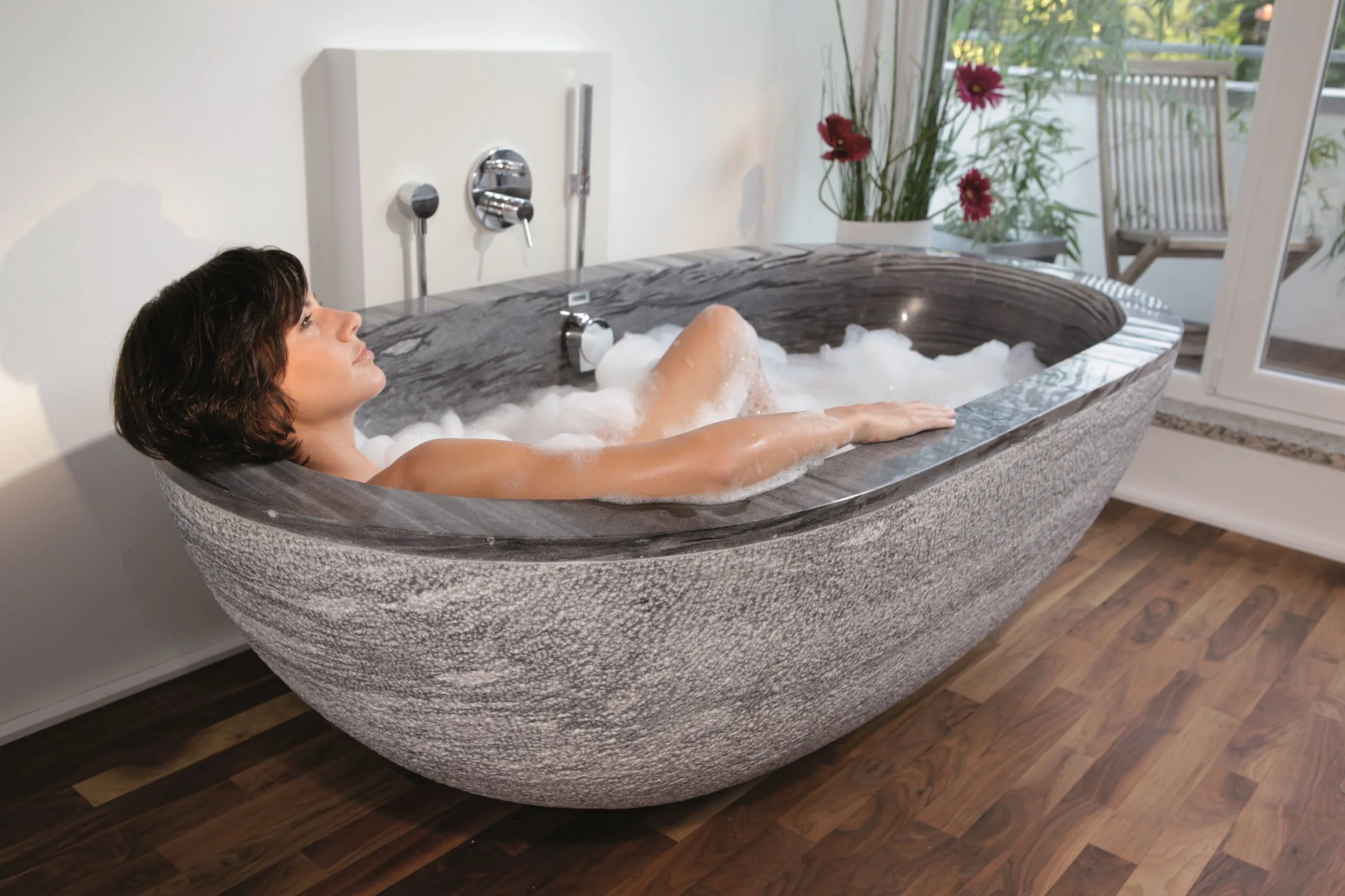 Luxusbad mit freistehender Naturstein-Badewanne und hochwertiger Badarchitektur