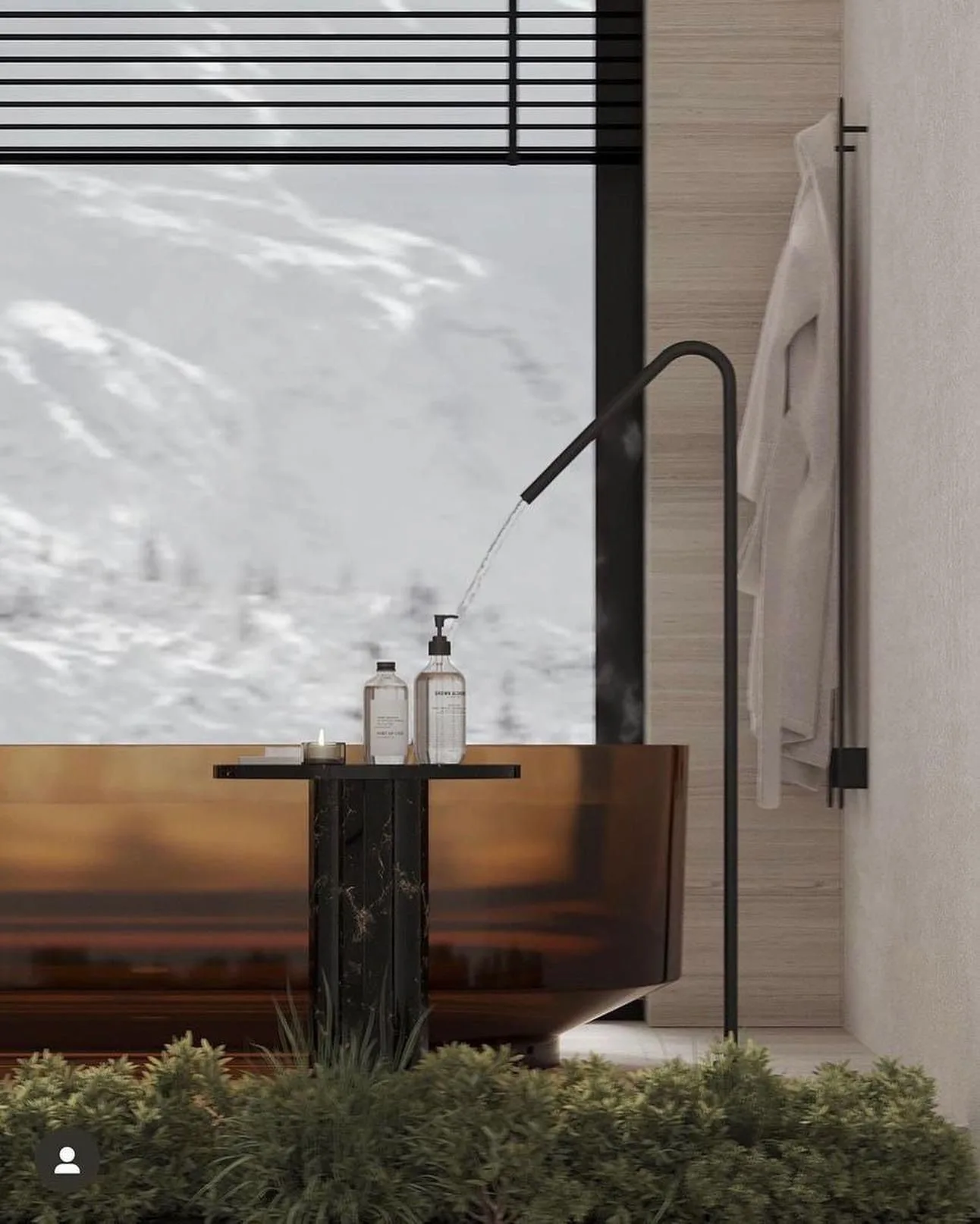 Luxus‑Spa‑Bad mit Amber‑Badewanne vor Panoramafenster, moderner schwarzer Wasserspeier, Naturpflanzen im Vordergrund und Schneelandschaft im Hintergrund.
