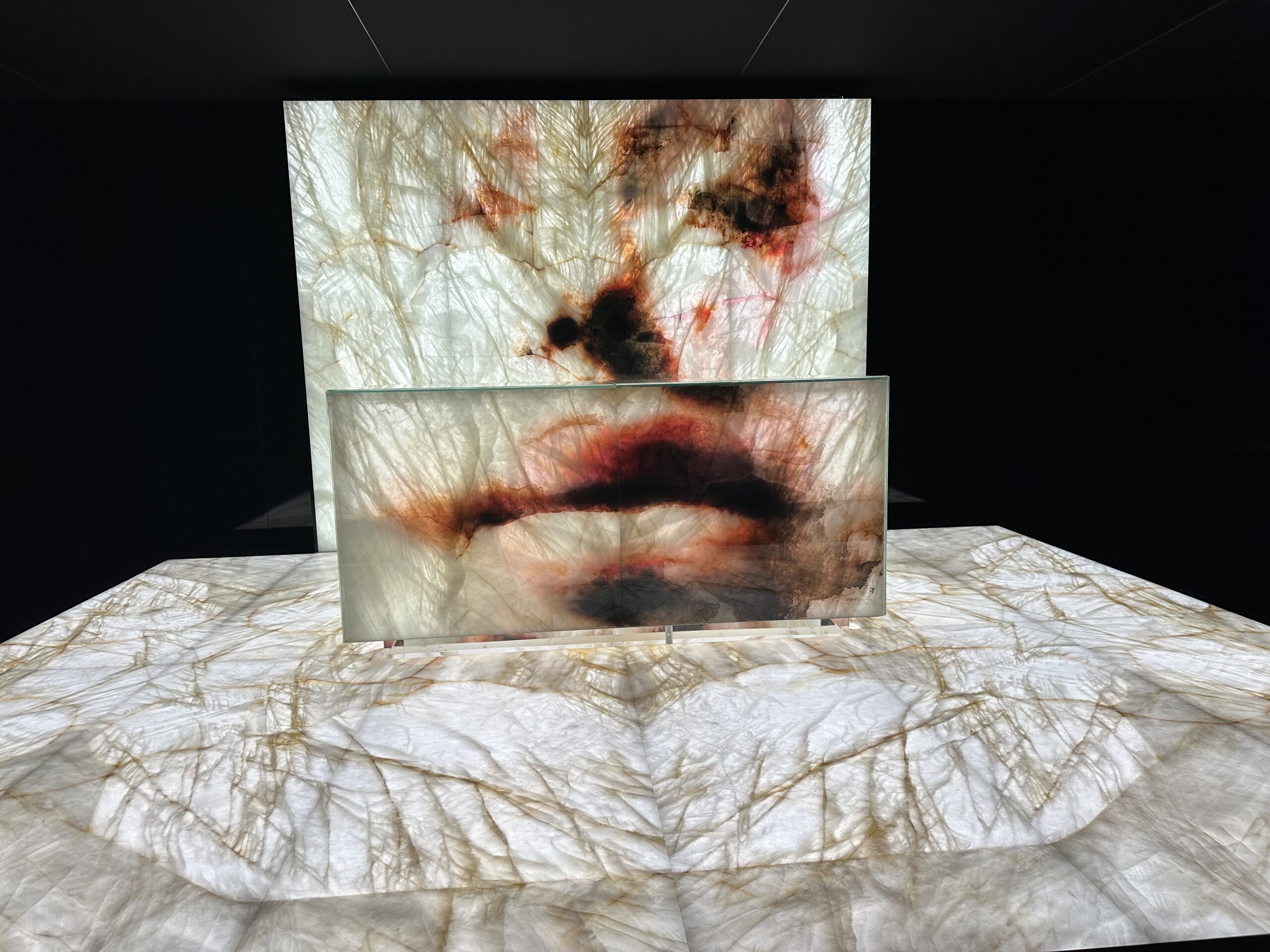 Beleuchtete Naturstein-Installation „The Language of Stone – Vision of Art“ von Antolini × Murran Billi auf der Marmomac 2025, kunstvoll inszenierter Quarzit mit roten Akzenten.